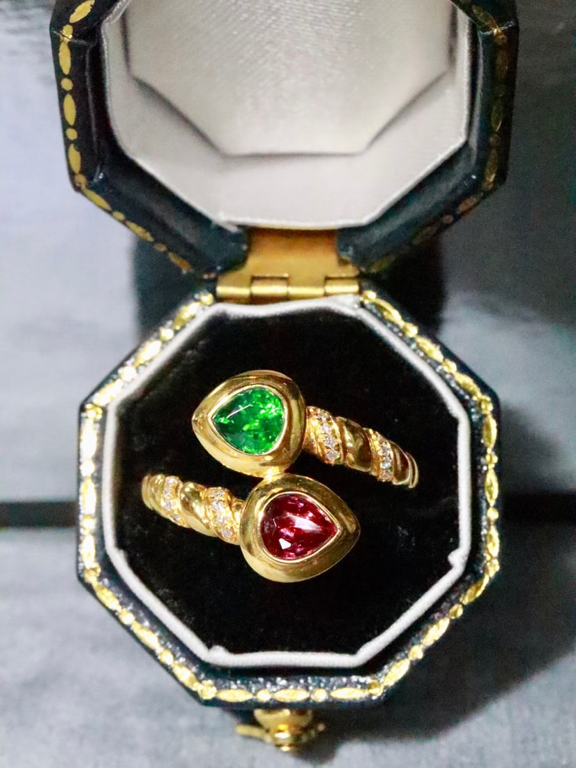 18K Gold Ruby and Tsavorite Ring: This 18K Gold Ruby and Tsavorite Ring artfully utilizes a dual-stone structure to highlight the natural hues of the gemstones. The vibrant ruby, unheated to preserve its pure allure, and the vivid