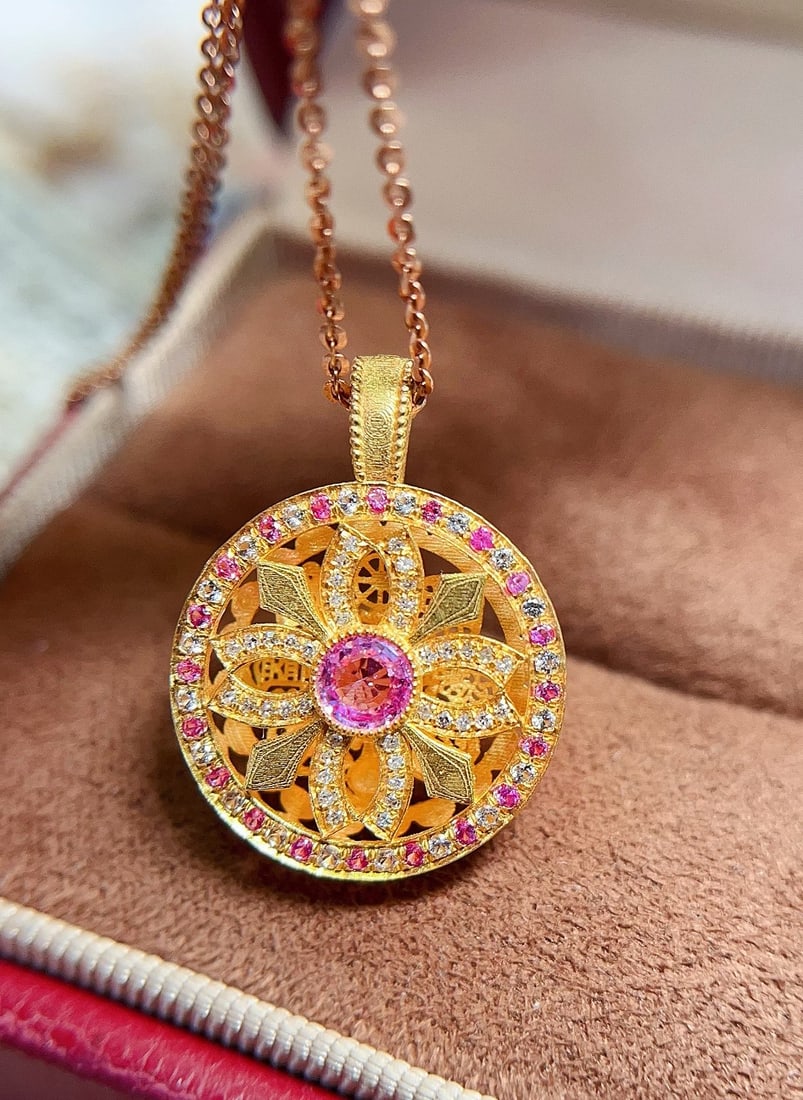 18K Gold Sapphire Pendant: This pendant exudes an exquisite and brilliant charm, crafted with a delicate pink sapphire that captures attention with its vibrant allure. The double-sided hollow design is inspired by traditional