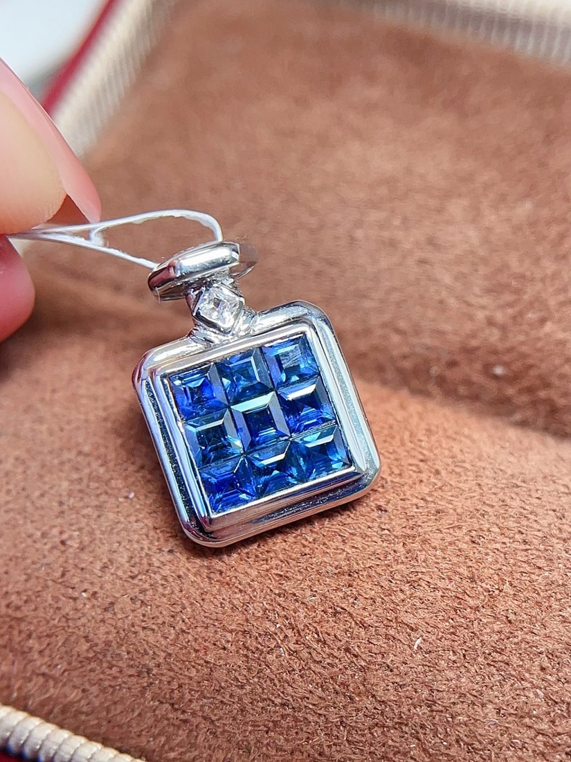 18K Gold Sapphire Pendant: This 18K Gold Sapphire Pendant exudes a regal charm with its exquisite design. The royal blue princess-cut sapphire is set in a bezel-free setting, allowing its vibrant color to shine through