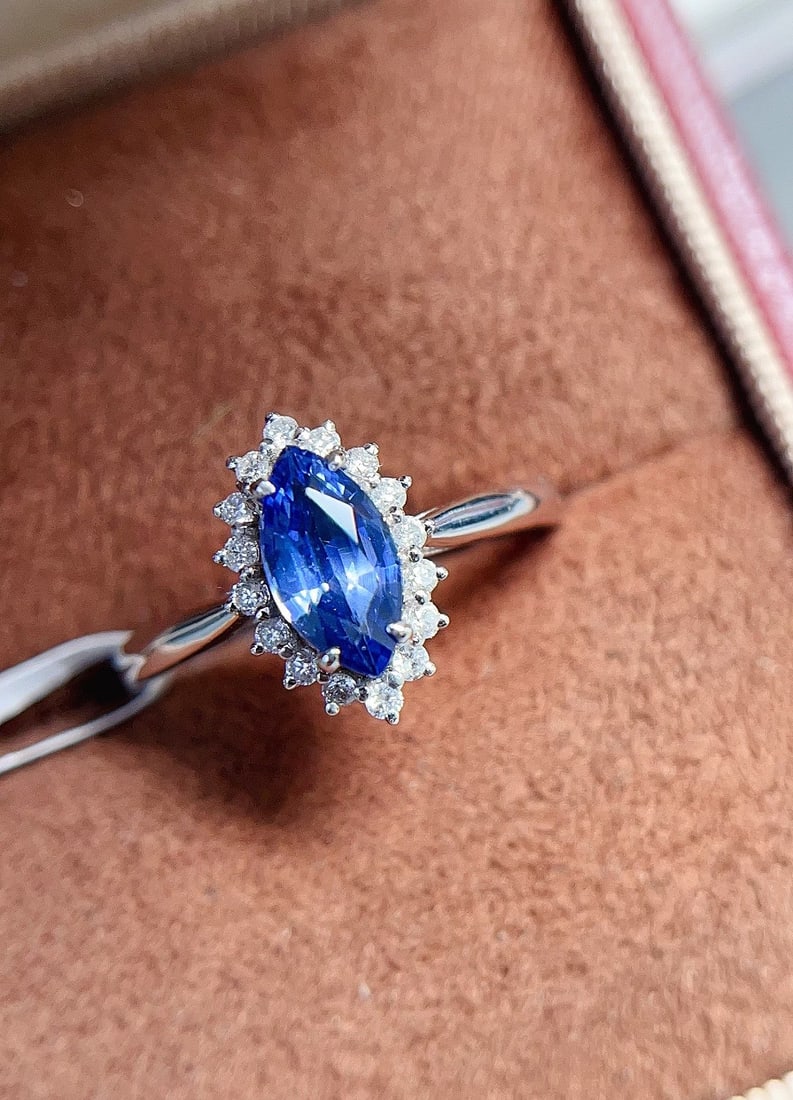 18K Gold Sapphire Ring: This 18K Gold Sapphire Ring is a masterpiece that exudes elegance and sophistication. Featuring a distinctive marquise cut, the sapphire is like a glassy treasure, catching the light in the most
