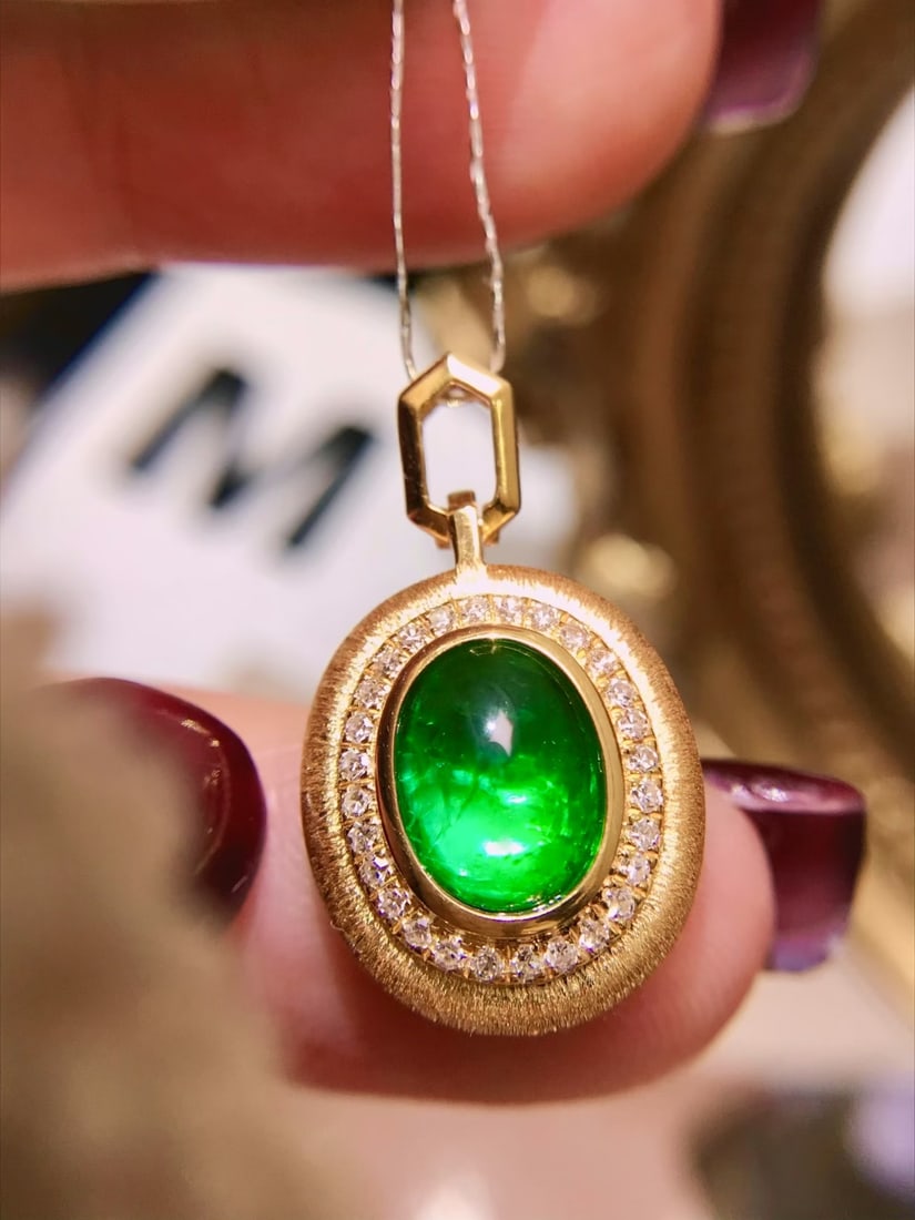 18K Gold Emerald Pendant: This 18K Gold Emerald Pendant showcases a stunning 2.2ct emerald that radiates a vivid green brilliance, reminiscent of a glowing beacon. The pendant's exceptional fluorescence adds a captivating