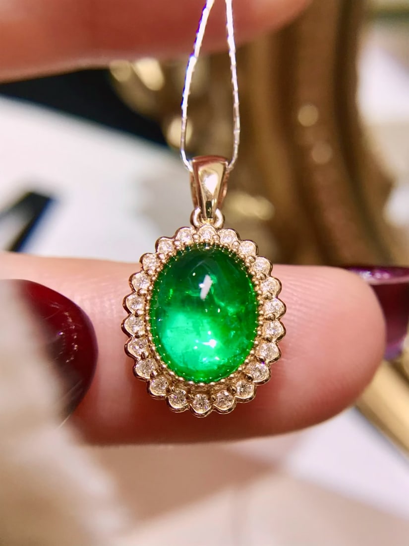 18K Gold Emerald Pendant: This exquisite pendant showcases a high-quality emerald that dazzles with its vivid green hue and remarkable translucency. The gemstone's captivating fluorescence makes it a true statement piece,
