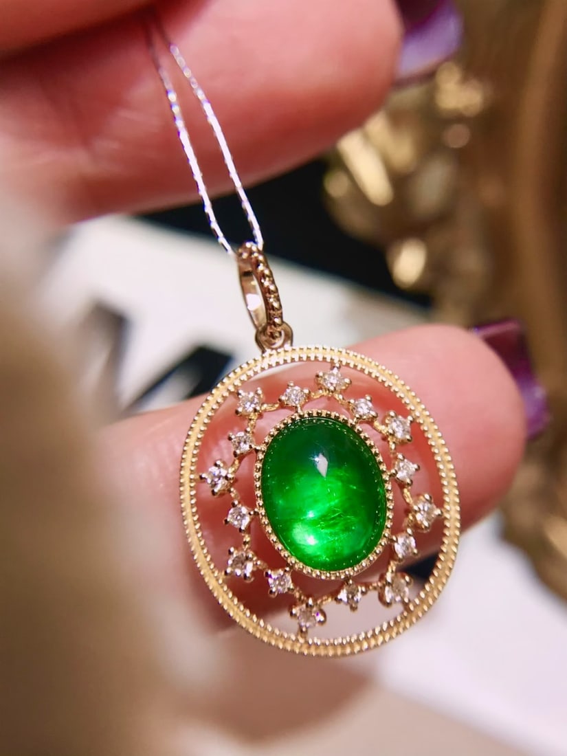 18K Gold Emerald Pendant: This pendant showcases a high-quality emerald that radiates a vivid green hue with an exceptional brightness, almost like a walking light bulb. The fluorescent glow of the 1.5-carat main stone is