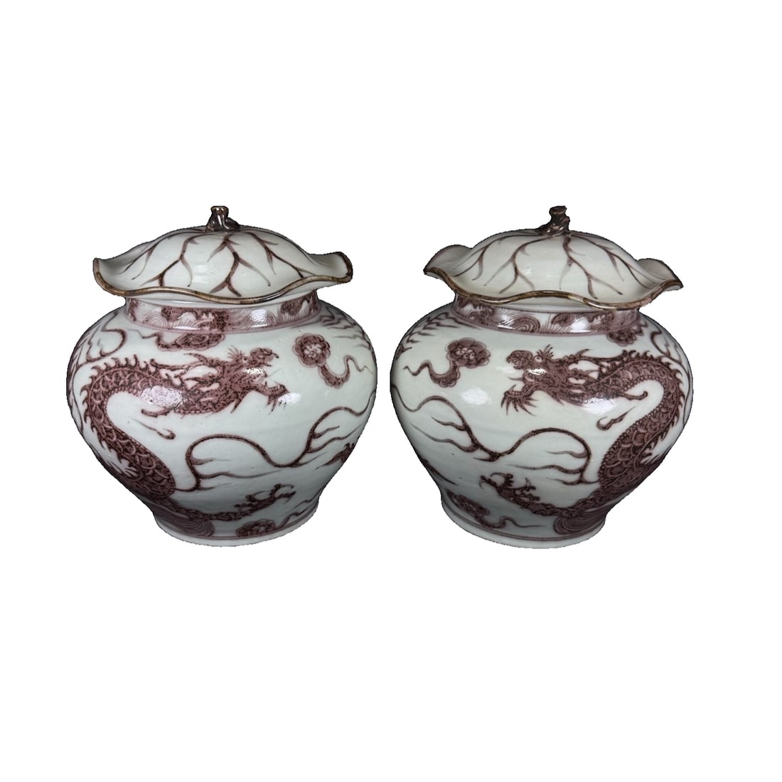 A pair of red dragon pattern lotus leaf covered jars from Yuan Dynasty.: This is a Yuan dynasty ceramic jar with a lotus leaf lid and red dragon motif. The jar has a round and bulging shape, with the mouth decorated with a lotus leaf-shaped lid, giving it a vivid and
