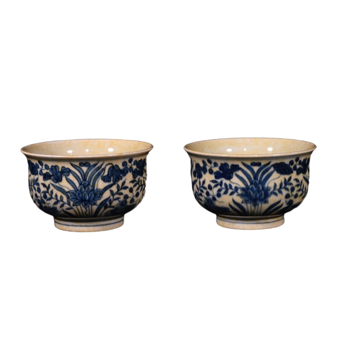 A pair of blue and white cups with mandarin ducks playing in the water: This is a Ming Dynasty Chenghua period red underglaze blue and white cup with a design of mandarin ducks playing in water. It is 4.8 centimeters tall and has a diameter of 7.6 centimeters. The shape o