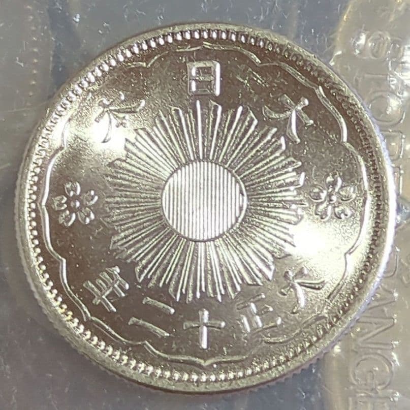 A small silver coin with a face value of 50 cents, from the 12th year of Taisho era (1923).: A small denomination silver coin with a face value of 50 cents, weighing 4.99 grams, from the 12th year of Taisho era (1923).