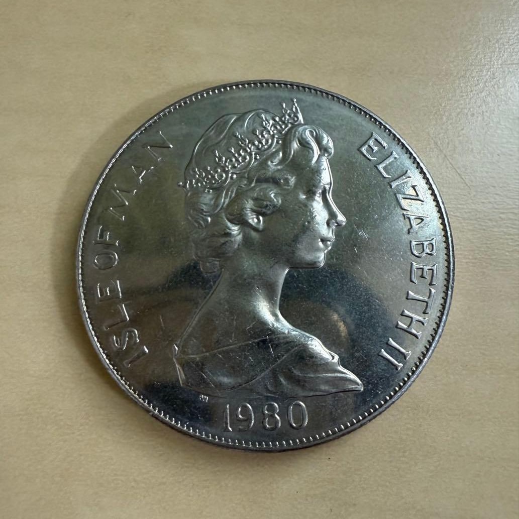 1980 Isle of Man Queen Elizabeth II 1 Crown coin: A set of coins featuring the portrait of Queen Elizabeth II was issued in the Isle of Man in 1980; as well as a commemorative coin for the Moscow Olympics.Country: Isle of ManYear: 1980Person: Queen E