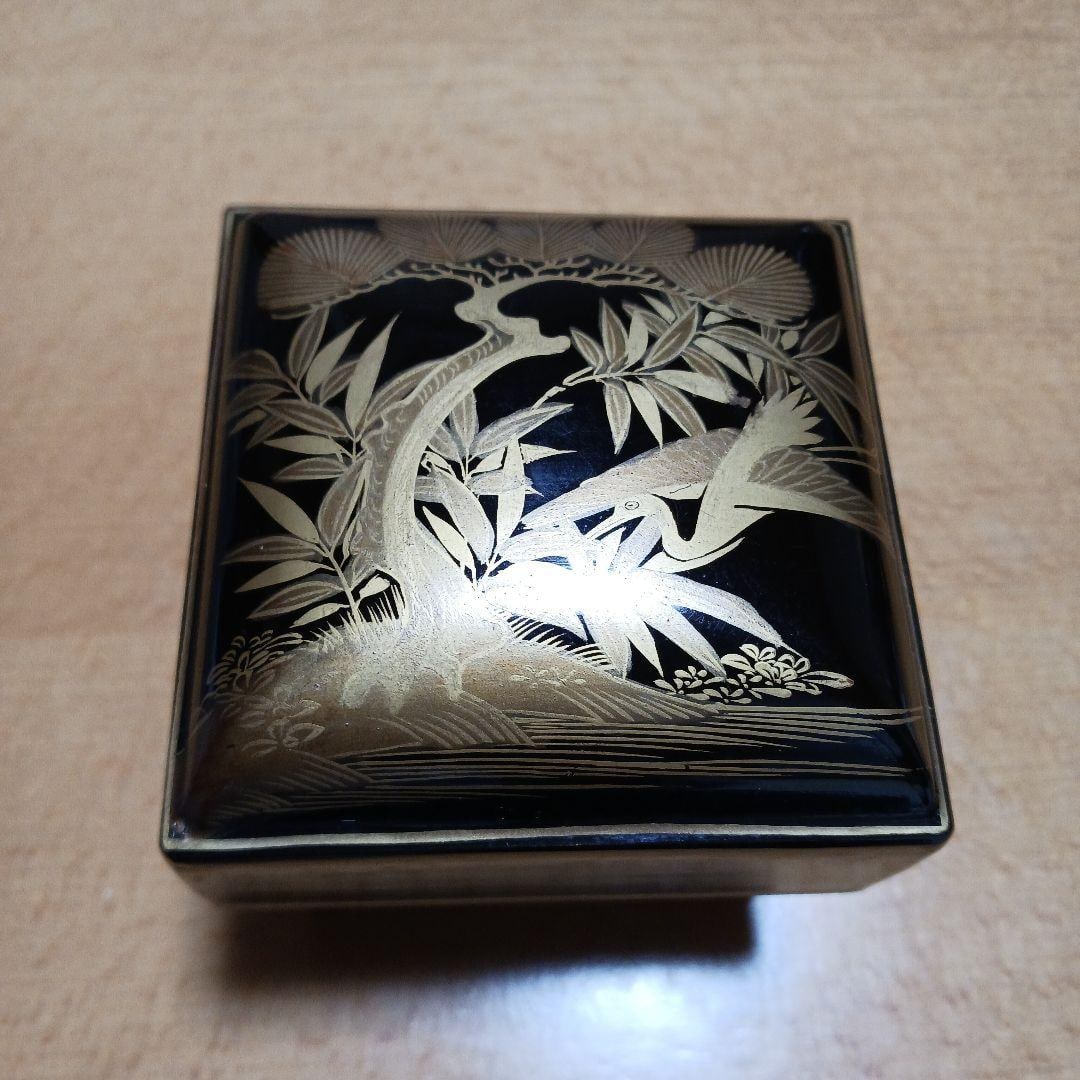 Lacquerware box: This is a lacquer box with a design of pine trees and birds painted on it. There is some slight chipping on the lacquer at the edges. It is very small and perfect for storing small jewelry!DimensionsB