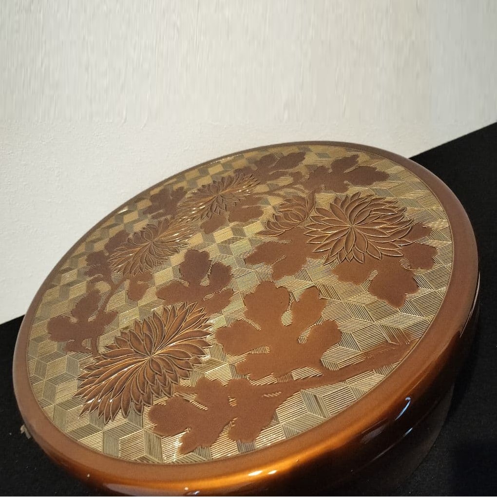 Brown lacquerware with floral pattern.: This water container is decorated with exquisite floral patterns, enhancing its visual appeal.It is made of lacquerware, combining durability and aesthetics.It measures 31 cm (length) x 31 cm (width)