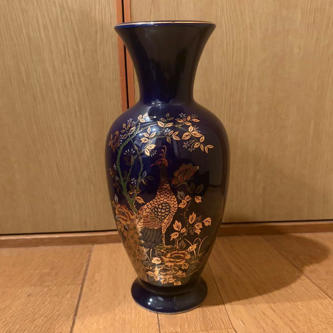 Navy blue lacquer vase decorated with peacock pattern.: A beautiful dark blue lacquer vase with a peacock pattern in gold foil painted on the body.