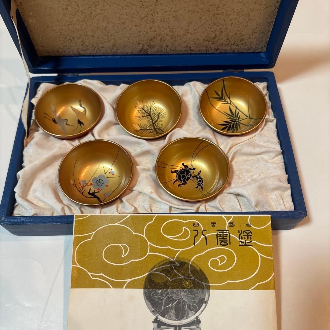 A set of 5 lacquerware cups with patterns of cranes and pine trees.: A set of 5 lacquerware cups, featuring patterns of cranes and pine trees.