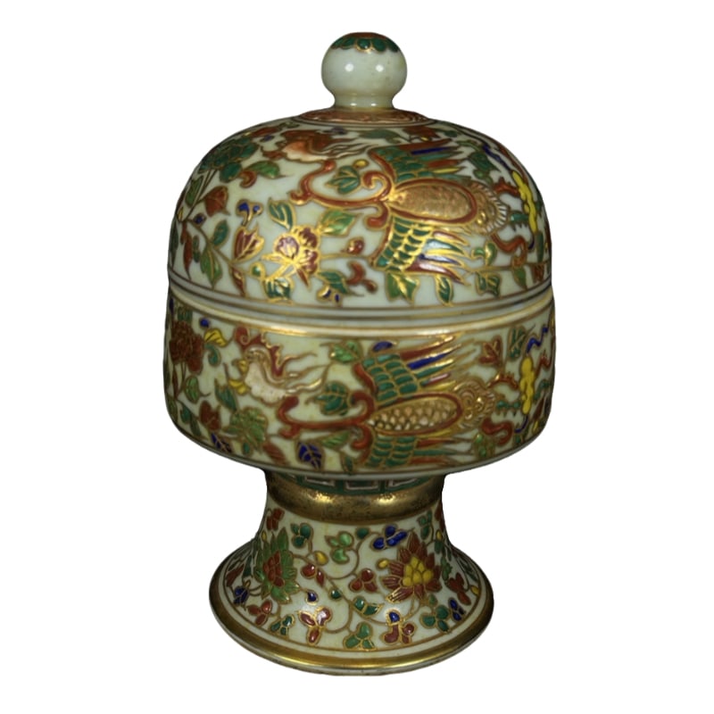 Ming Dynasty Xuande five-colored gold-painted phoenix pattern covered jar: This is a Ming Dynasty Xuande period five-colored gilt phoenix patterned covered jar. The shape of the vessel is elegant, with a rounded and thick body and lid, a slightly open foot, balanced proporti