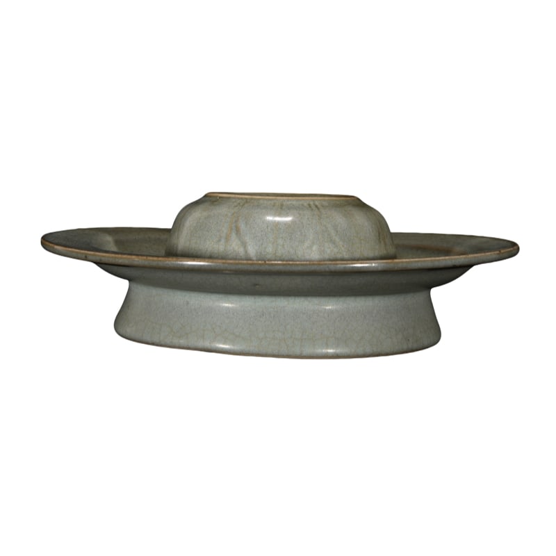 Song Ru kiln cup stand: This Song dynasty Ru kiln cup stand measures 6 centimeters in height and 18 centimeters in diameter. The vessel has a dignified and elegant shape, with smooth lines and a slightly flared bottom, makin