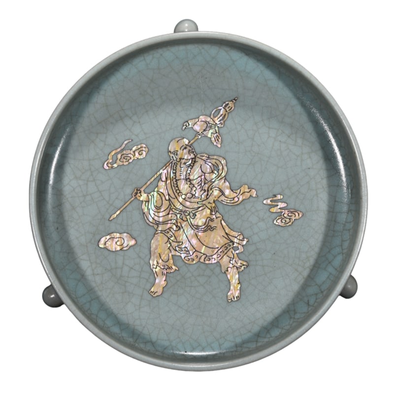Song Ru kiln tripod washer with mother-of-pearl inlay of human figures: This is a Song Dynasty Ru kiln tripod wash basin, with a total height of 6 centimeters and a diameter of 19 centimeters. The vessel has a dignified shape, with three stable supporting feet. The body o