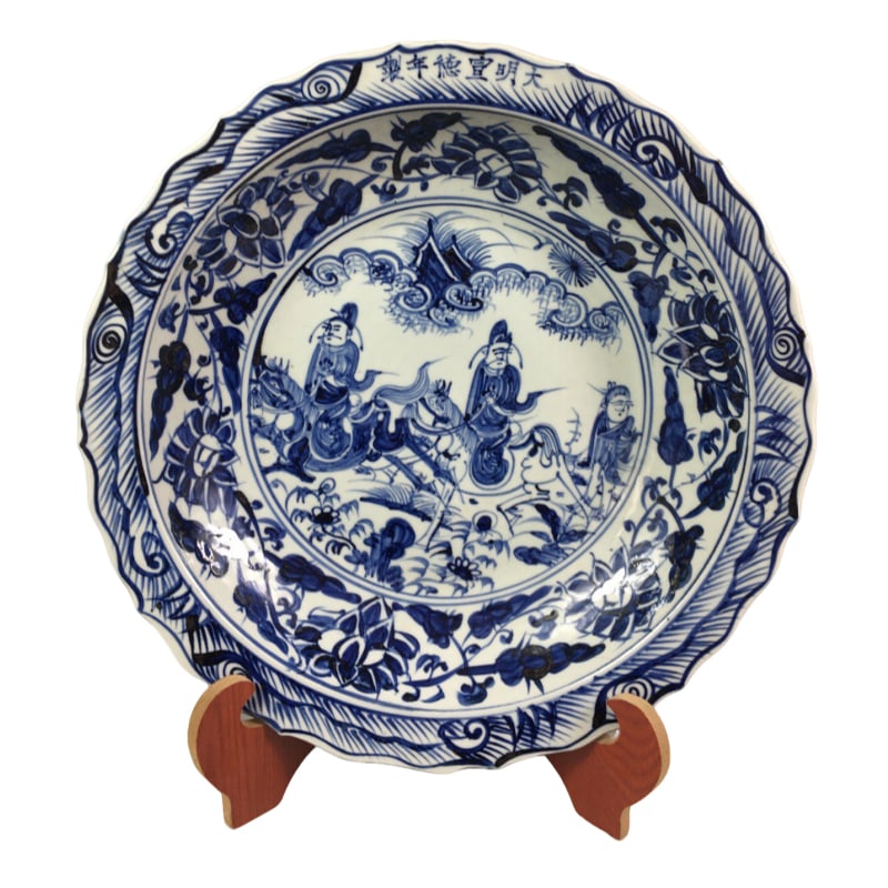 Ming Xuande blue and white dish with figure design: This Ming Xuande blue and white porcelain plate features a diameter of 39.5 centimeters and a height of 7.5 centimeters. The shape of the vessel is dignified and elegant, with undulating waves along t