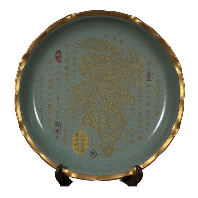 Song Ru kiln plate with dragon pattern and flower mouth inscription: This Song Dynasty Ru kiln plate features a dragon-patterned floral design on the mouth, with a height of 5.5 centimeters and a diameter of 29.5 centimeters. The shape of the plate is dignified, with a