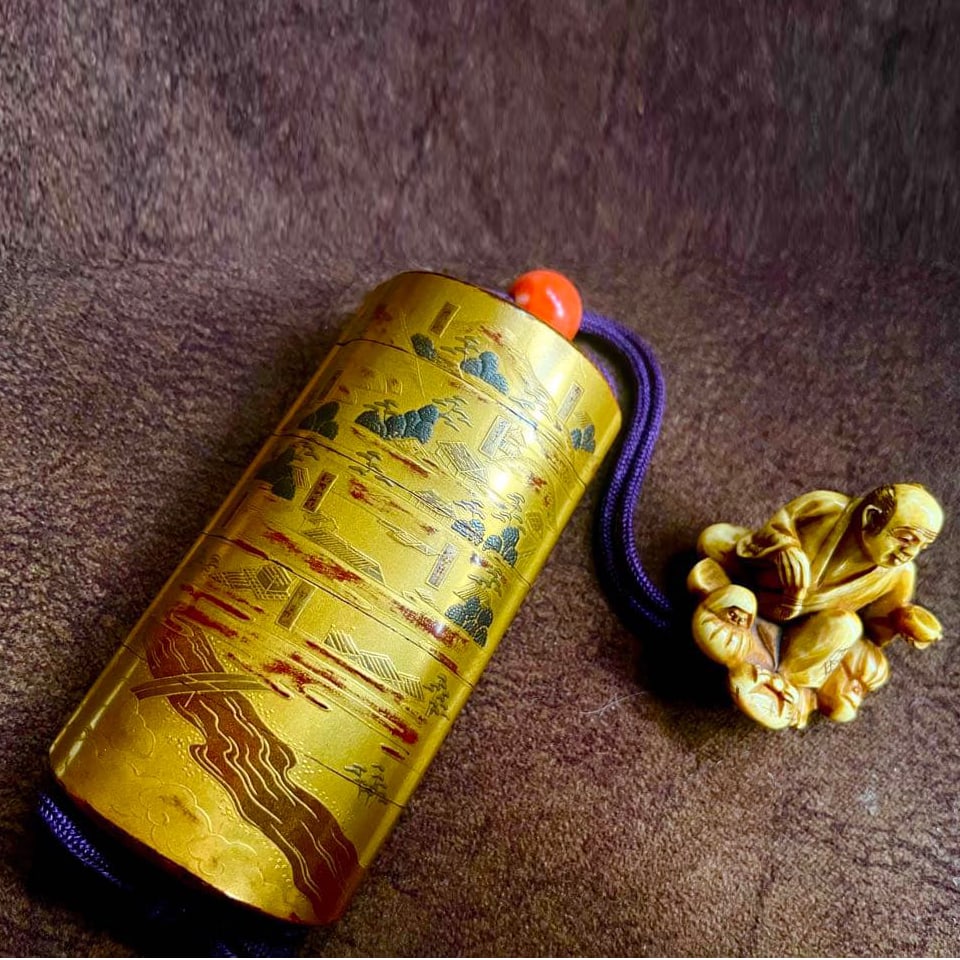 A five-tier gold lacquer inro (small container) crafted by Kajikawa, containing a netsuke (miniature (1 of 8)