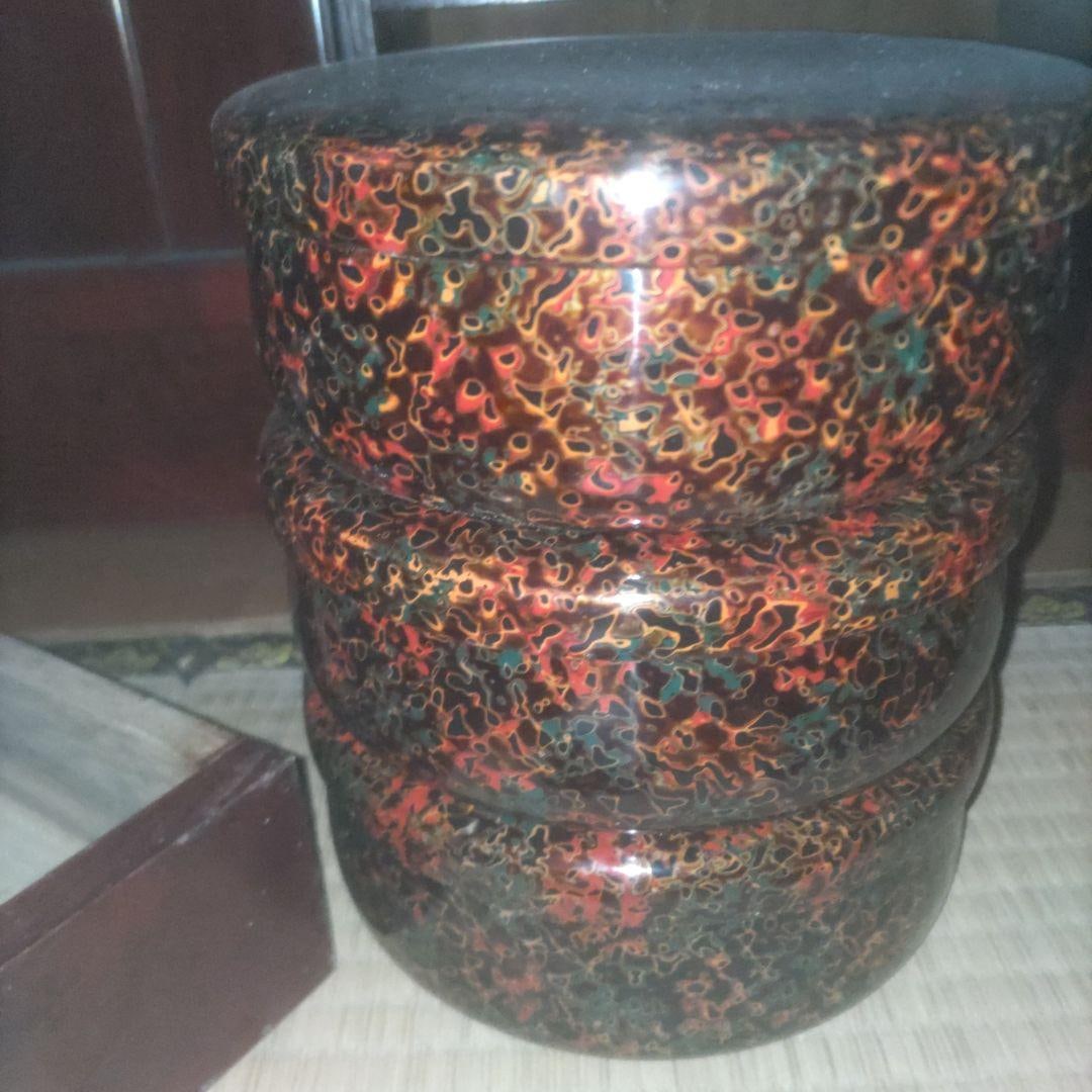 Set of Three Tsugaru Lacquerware Containers: This inrO (small decorative box) is crafted from high-quality lacquer, combining durability with aesthetic appeal. The design predominantly features vibrant red, black, gold, and green colors,