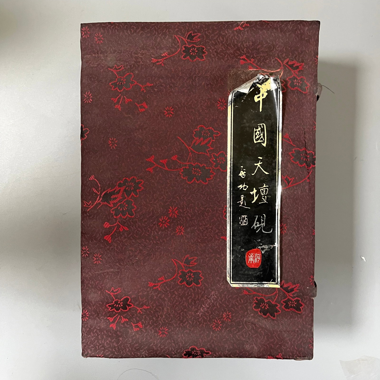 Tian Tan Inkstone: Tian Tan Inkstone, 18x11x2 cm.The inkstone's main body is naturally shaped, with a deep brown color and a smooth, jade-like surface. The upper right corner features a relief carving of a mythical