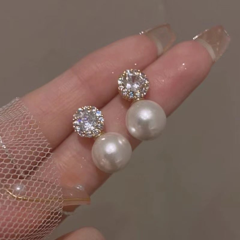 Edison Pearl Earrings: This pair of earrings features exquisite 11-12mm round natural Edison pearls that embody timeless elegance. The lustrous pearls are perfectly complemented by their clean and neat design, making them a