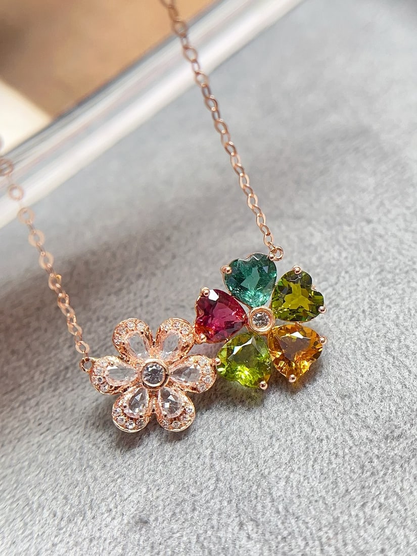 18K Gold Tourmaline Necklace: This 18K gold tourmaline necklace features a heart-cut tourmaline with a rainbow candy color, exuding a glass-like brilliance. The exquisite floral design is perfectly set with 24 diamonds and 8 white