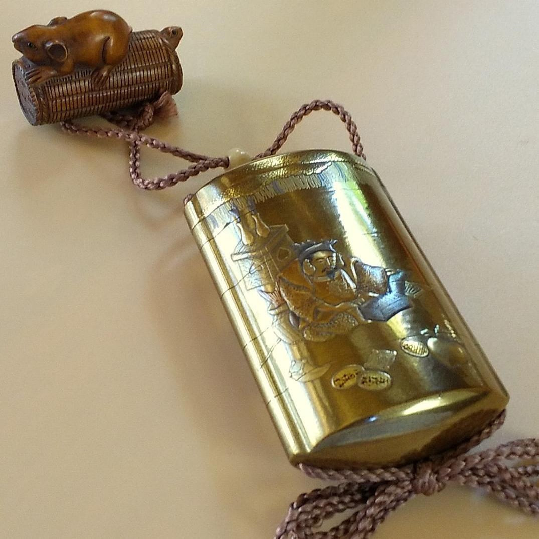 Lacquered inro (small container) and netsuke (miniature sculpture), depicting Daikokuten and Ebisu.: Lacquered inro (small container) and netsuke (miniature sculpture), depicting Daikokuten and Ebisu (mouse in a bamboo basket, inscribed "Kowa"). As it is an antique, there are some age-related wear ma