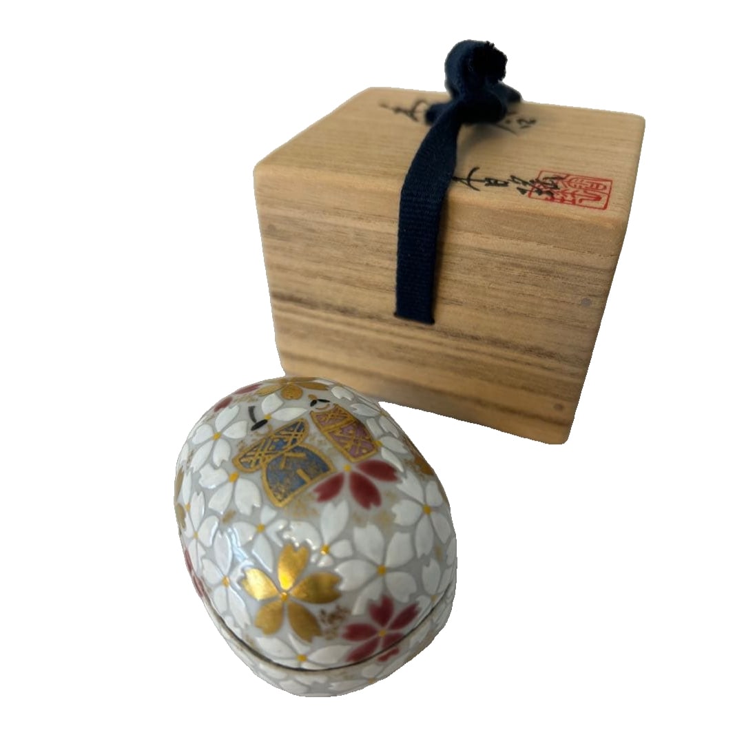 Porcelain egg-shaped incense box, decorated with floral patterns and gilt edges, accompanied by a: This is a ceramic egg-shaped incense box, adorned with splendid floral patterns and gold embellishments, accompanied by charming male and female figurines. The consignor purchased it at a solo