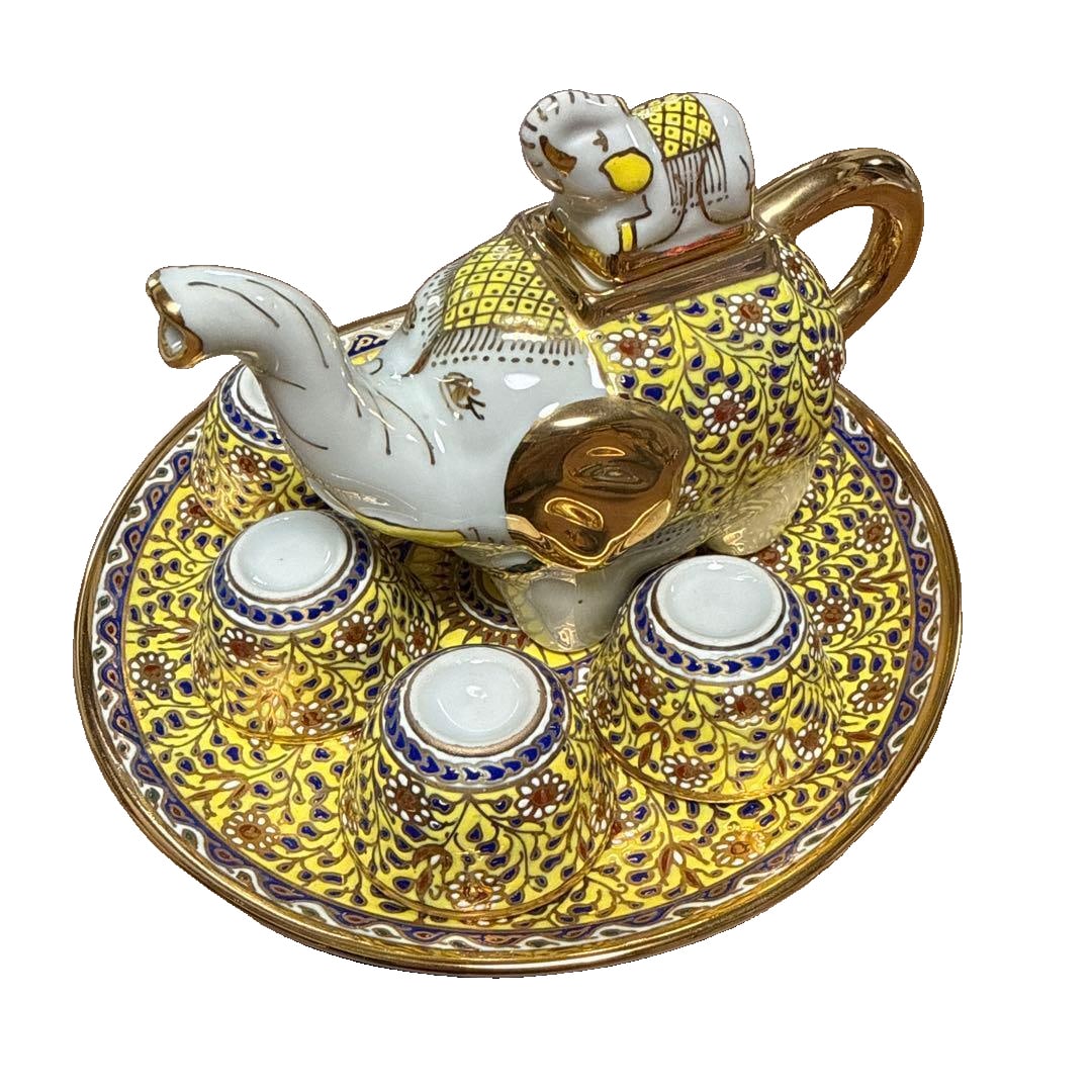 Tea set with elephant-shaped teapot and teacups, brand new and unused.: A set of ceramic teapot and teacups, designed in the shape of elephants, adorned with luxurious gold and blue patterns. Design: A teapot in the shape of an elephant and five teacups. Color: White, acc