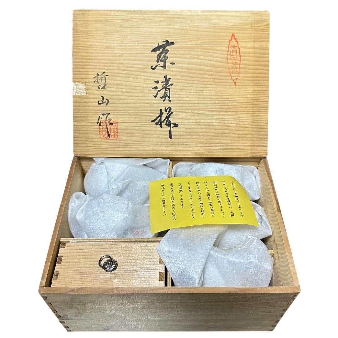 A set of rice bowls and chopstick rests made by Arita ware Tetsuzan.: A set of rice bowls and chopstick rests made by Tetsuzan of Arita ware. A set of five ceramic teacups decorated with floral patterns, stored in a wooden box. Box Material: Wood Box Condition: Good Pac