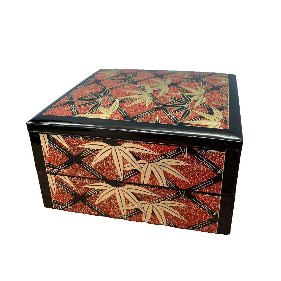 A lacquerware bento box with bamboo pattern in maki-e technique, double-layered.: This luxurious two-tiered bento box is adorned with exquisitely painted traditional bamboo patterns. The contrast of black and vermilion, along with the maki-e style decoration resembling gold leaf, a