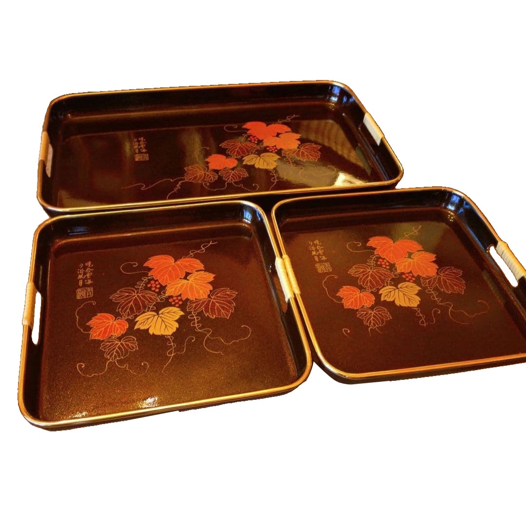 A set of three lacquer trays, decorated with grape motifs.: A set of three synthetic lacquer trays, decorated with grape motifs. The base material is synthetic resin, making them very lightweight. Quantity: Set of 3 Dimensions: Large 48 x 29 cm, Small 27 x 27 