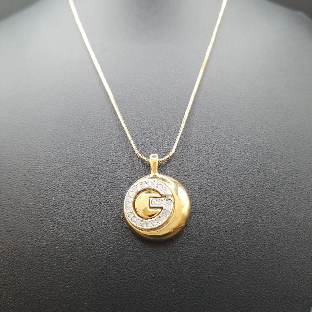 Second-hand - Givenchy G Logo Crystal Circular Pendant Necklace: This Givenchy G logo necklace exudes luxury with its striking circular design, G logo, and water diamonds as its main highlights. Simply wearing it around your neck can instantly create an elegant and
