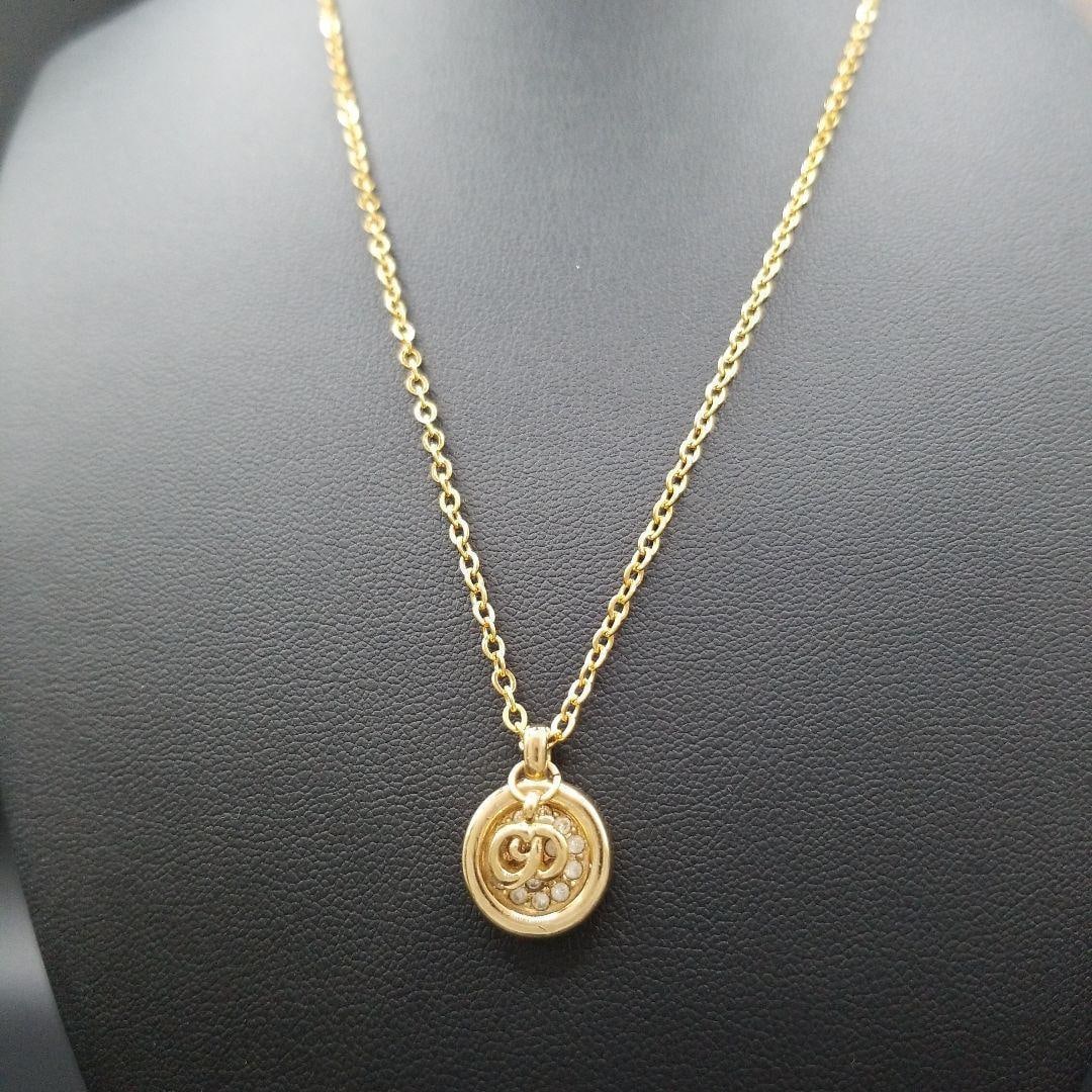 Second-hand Dior CD logo round gemstone necklace, vintage: This Dior CD logo necklace shines with elegant radiance. The central logo and water diamonds sparkle on the chest, showcasing a charming style. The luxurious gold color can elevate the style of any ou