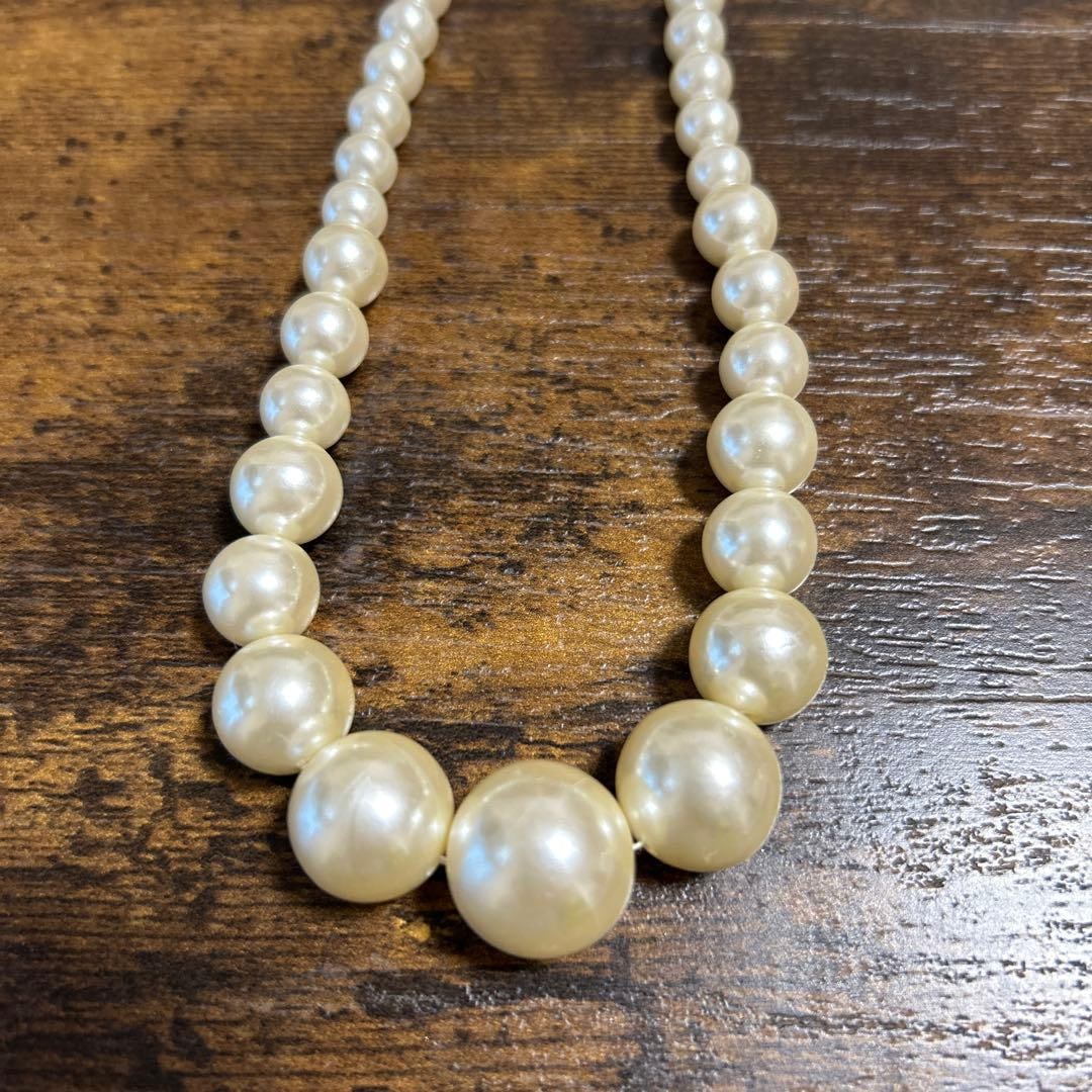 Second-hand - white pearl necklace, approximately 47 centimeters.: A multi-layer white pearl necklace, approximately 47 centimeters in length. Material: Pearls Color: White Fastening: Chain clasp Design: Gradual arrangement of pearls Length: Approximately 47