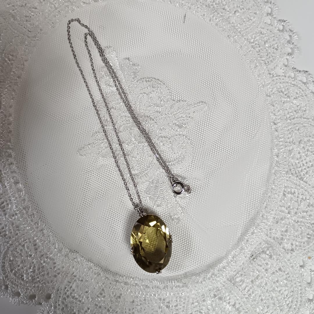 Second-hand - Yellow Crystal Oval Cut Necklace: A silver necklace with a large oval-cut yellow crystal embedded on it. Color: Yellow Material: Silver Design: Large oval-cut stone Gemstone size: Approximately 25 mm x 20 mm Chain length: