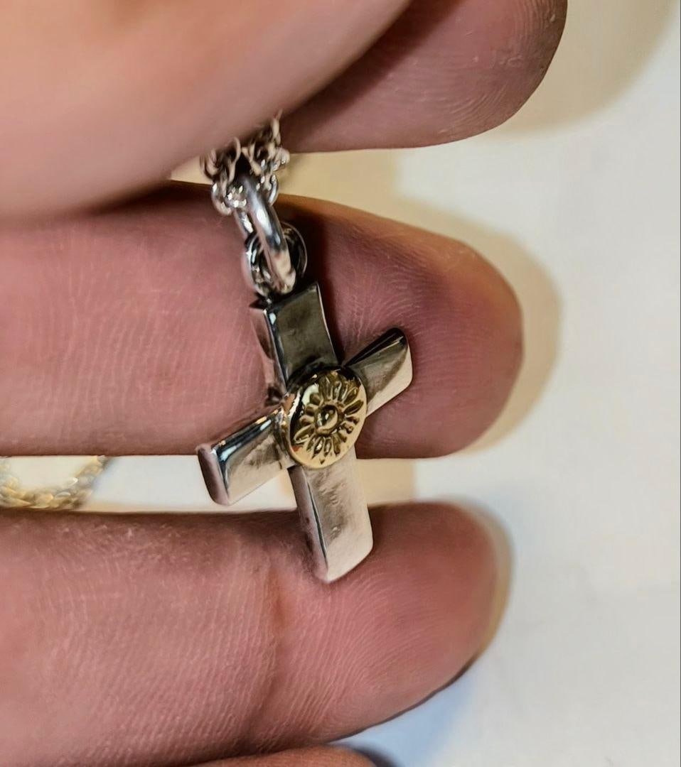 Second-hand - 925 sterling silver gold-plated cross pendant: A cross-shaped pendant made of sterling silver (925) and gold, featuring a floral design in the center. Material: 925 Sterling Silver Design: Cross with floral pattern Engraving: 925 (Note: Pendant on