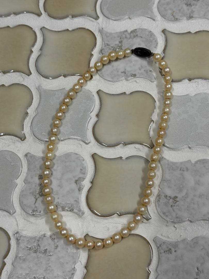 Second-hand - Pearl Necklace: A pearl necklace with a pearl clasp. Material: Pearl Clasp: The clasp has a pearl on it.