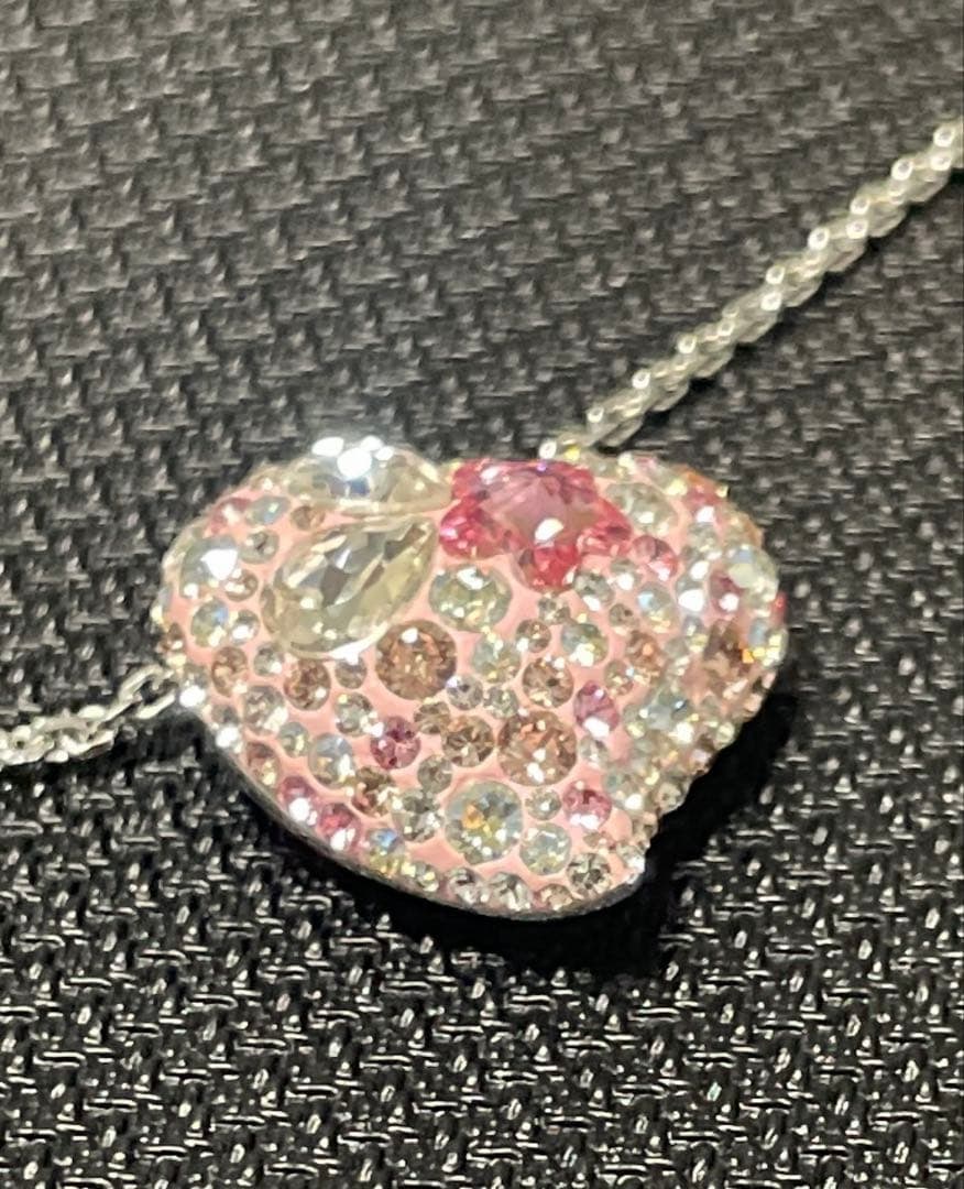 Second-hand - Swarovski heart-shaped necklace in pink: Swarovski Necklace Chain Length Approx. 37.0 cm + 4 cm (adjuster) Pendant Size 2.0 cm x 2.0 cm Color Silver x Pink This is a very cute pink heart necklace.