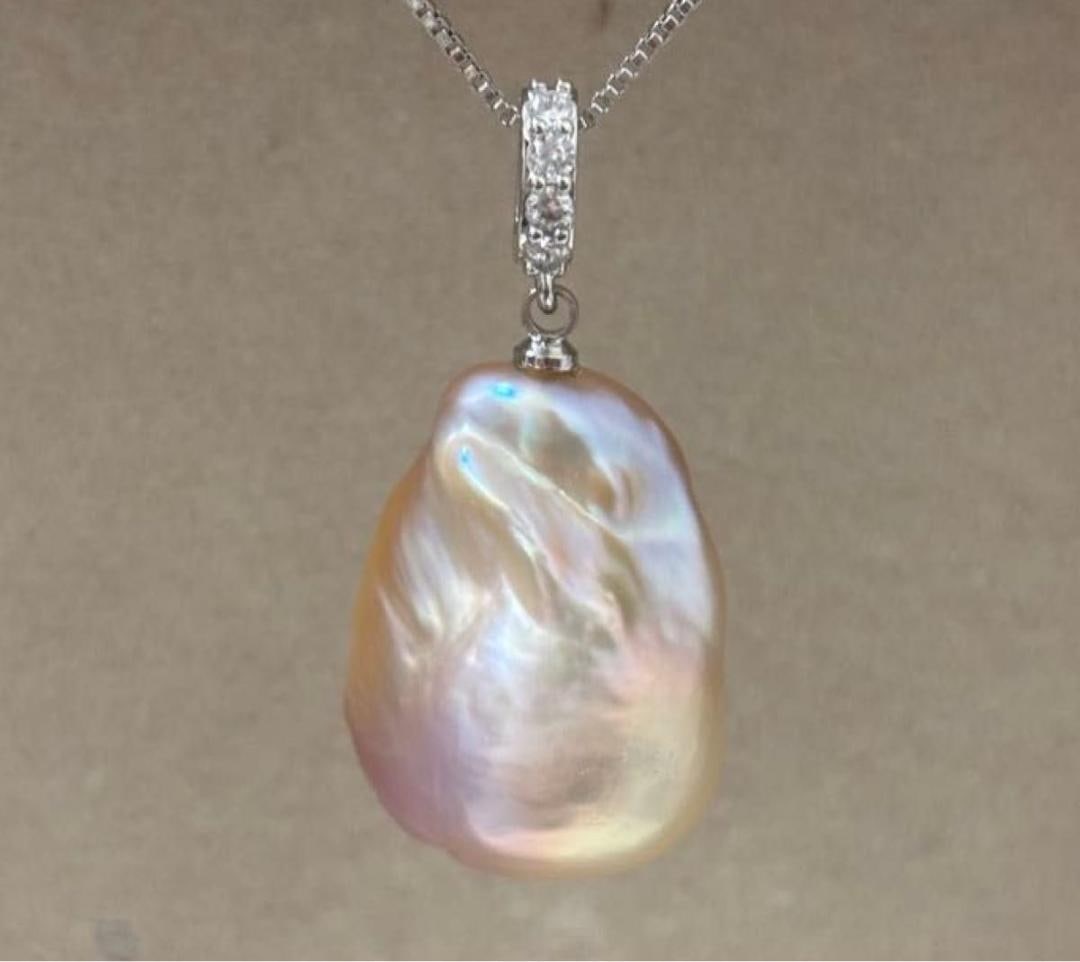 Second-hand - Large Baroque pearl pendant, silver, inlaid with cubic zirconia: This pendant is set with a large, beautiful baroque pearl in a soft pink color. It has a shiny luster, natural shape, and full of charm, adding a touch of elegance to your neckline. The pendant is set