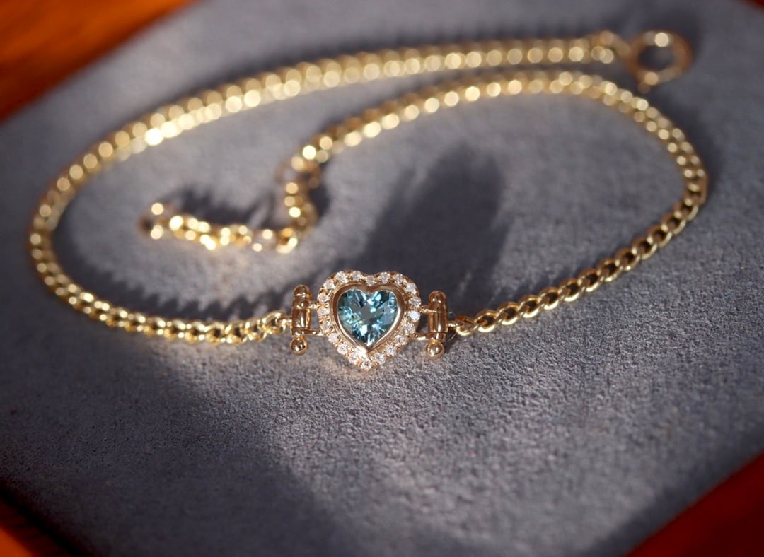 18K gold ocean blue sapphire diamond bracelet: This bracelet is meticulously crafted in 18K gold, set with Santa Maria aquamarine, presenting a romantic heart-shaped design, like a sweet love story, filled with anticipation. The bracelet's design