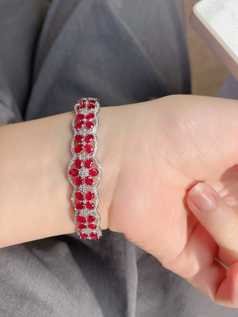 18K Gold Ruby Bracelet: This 18K gold ruby bracelet showcases unparalleled elegance and luxury with its unique intricate floral design and wide style. The pigeon blood red hue of the ruby resembles a burning flame, exuding