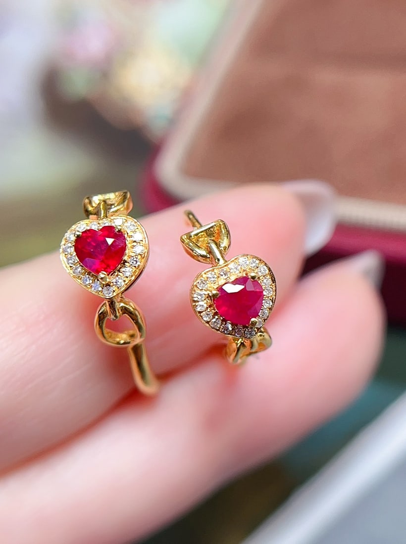 18K gold ruby earrings: These earrings are meticulously crafted in 18K gold, set with pigeon blood red rubies. The heart-shaped cut design gives a sweet touch. The intense color of the rubies shines brightly alongside the da