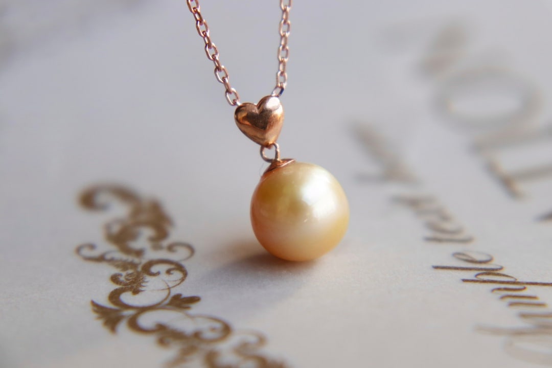 18K Gold Seawater Pearl Pendant (chain not included): This 18K gold seawater pearl pendant is stunning with its perfect flawless round shape and strong luster. The pearl's color is beautiful and captivating, exuding a natural noble quality, suitable for