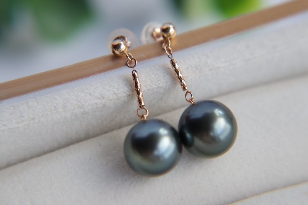 18K gold Tahitian pearl earrings: These earrings are crafted with 18K gold and feature Tahitian pearls, showcasing a luxurious and elegant style. The pearls have a size of 10 millimeters, displaying a perfectly round shape with