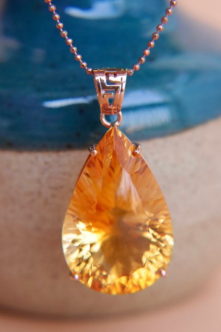 18K gold yellow crystal pendant (chain not included): This 18K gold yellow crystal pendant features a stunning 22.15-carat main stone at its center, showcasing mesmerizing fire color and pure crystals, perfectly capturing every angle of light. The color 