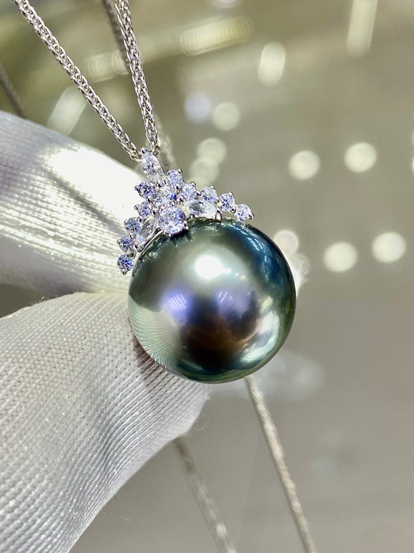 18K white gold Tahitian pearl pendant (chain not included): This pendant features an 18K white gold thick setting carrying a nearly 15mm Tahitian pearl, showcasing a pure and translucent greenish luster akin to ice and snow. Its perfectly round and slightly fl