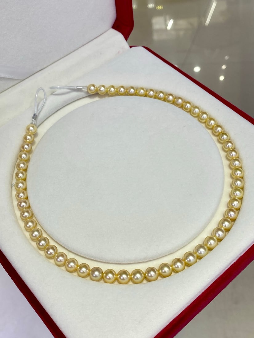Akoya Pearl Necklace: This Akoya pearl necklace features pearls that are perfectly round in shape, measuring 7.5-8 millimeters each. Despite having slight imperfections, the pearls maintain their noble quality, appearing f