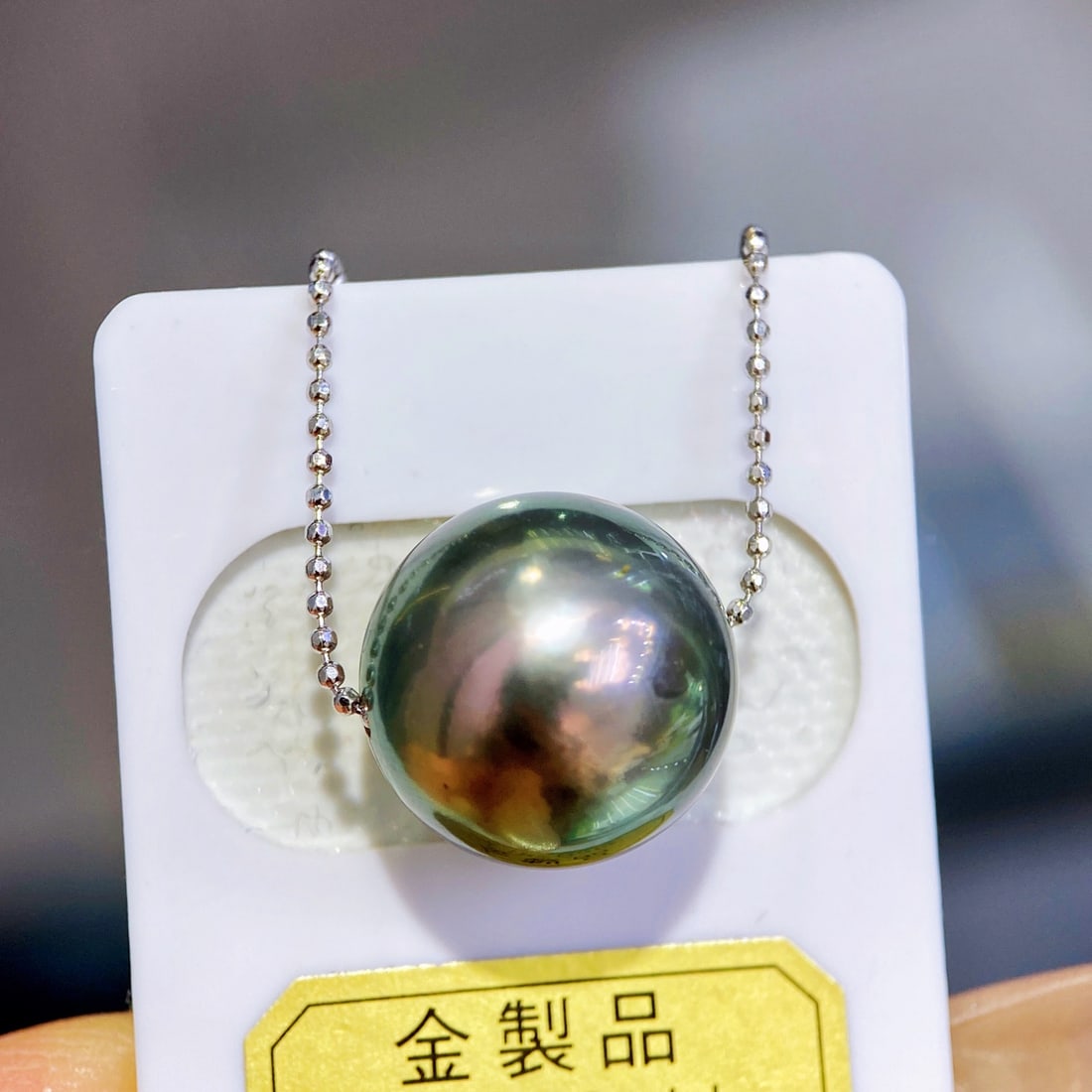 Peacock Green Pearl Necklace: This peacock green pearl necklace features unique Tahitian pearls as its highlight, with a pearl diameter reaching 13-14 millimeters, showcasing stunning perfectly round shape and high quality with