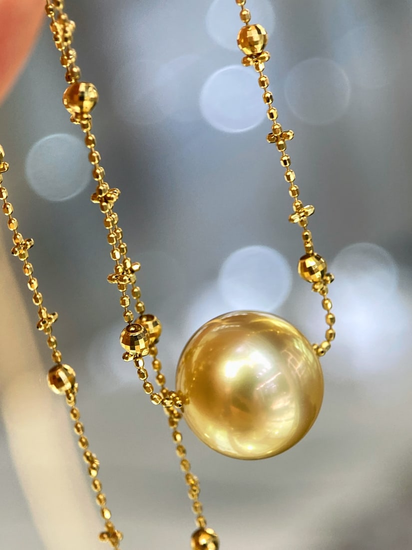18K gold South Sea pearl necklace: This 18K gold South Sea golden pearl necklace features a flawless 12mm perfectly round pearl as its centerpiece, emitting a rich golden glow, exuding a dreamy aura like that of a fairy. Its
