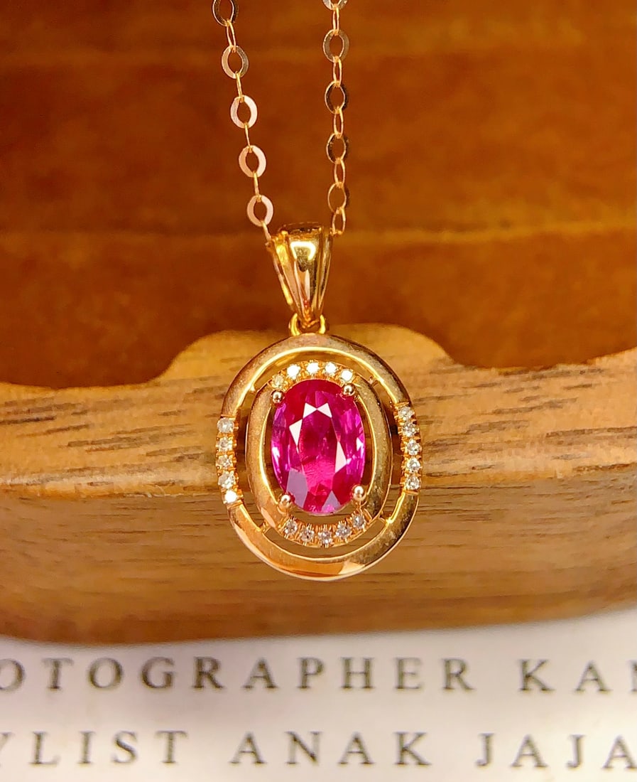18K Gold Ruby Pendant (Chain not included): This pendant features a natural untreated ruby as the main stone, symbolizing passionate and eternal love. The intense color of the ruby complements the 20 sparkling diamonds, showcasing unparalleled